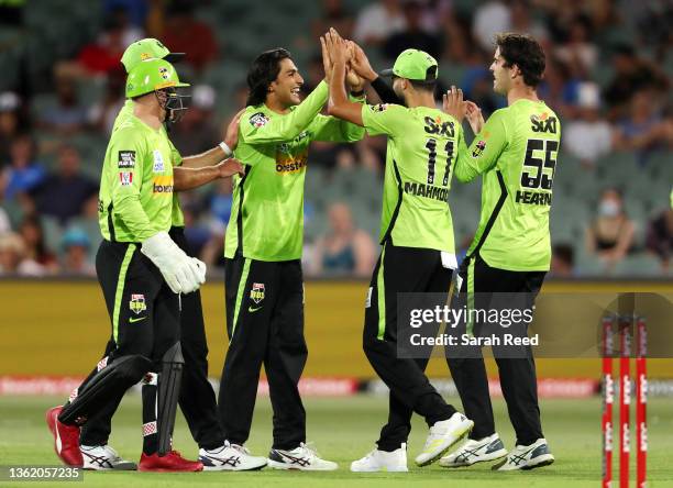 Jason Sangha of Sydney Thunder celebrates with team mates after the wicket of Thomas Kelly of the Strikers for 1 run during the Men's Big Bash League...