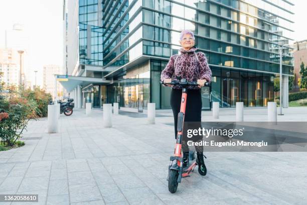 italy, fashionable senior woman on push scooter in city - eccentric people stock pictures, royalty-free photos & images