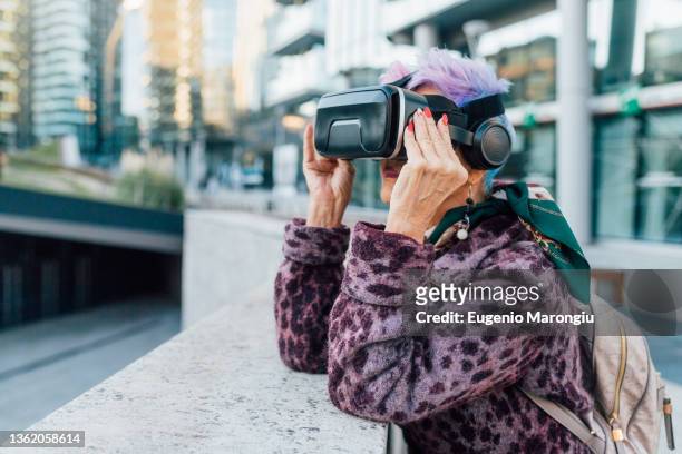 italy, fashionable senior woman withvrgoggles in city - senior colored hair stock pictures, royalty-free photos & images