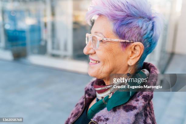 italy, smiling fashionable senior woman with purple hair - blue hair stock pictures, royalty-free photos & images
