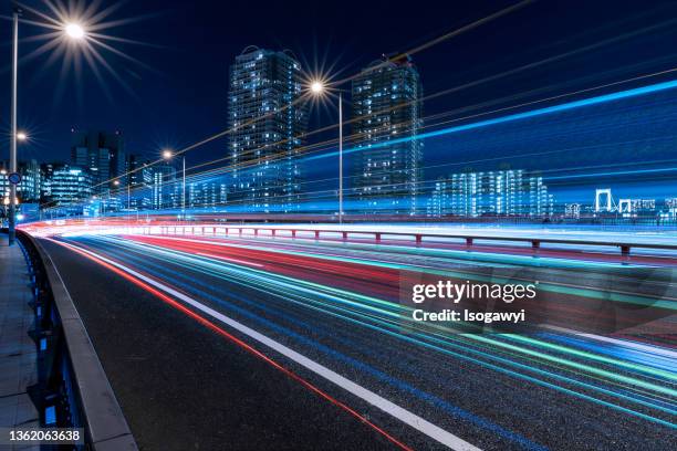 tokyo waterfront city skyline and light trails at night - light trail imagens e fotografias de stock