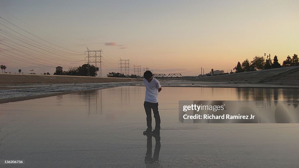 Boy standing in riverbed