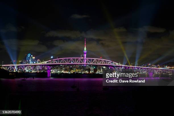 Light show from the Skytower and harbour bridge during Auckland New Year's Eve celebrations on January 01, 2022 in Auckland, New Zealand. The light...