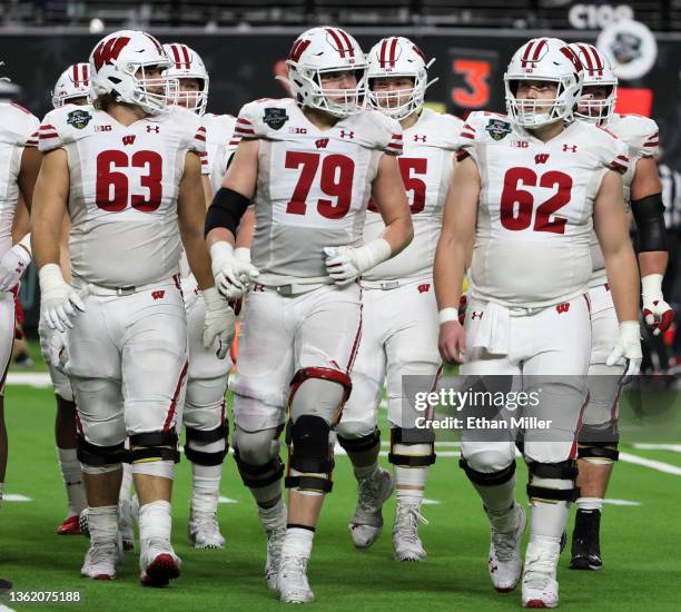 Offensive linemen Tanor Bortolini, Jack Nelson and Cormac Sampson of the Wisconsin Badgers walk to the line of scrimmage during the SRS Distribution...