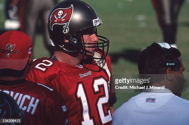 Quarter Back Trent Dilfer of the Tampa Bay Buccaneers discusses the next play during a time out with another Buccaneer Quarter Back and a Coach in a...