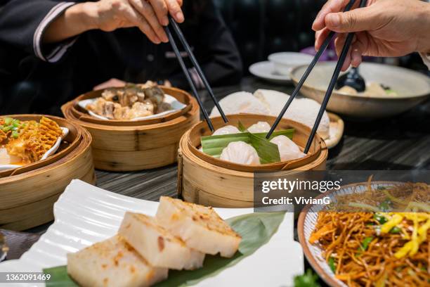 menschen essen guangdong dum sum mit essstäbchen im restaurant - dim sum stock-fotos und bilder