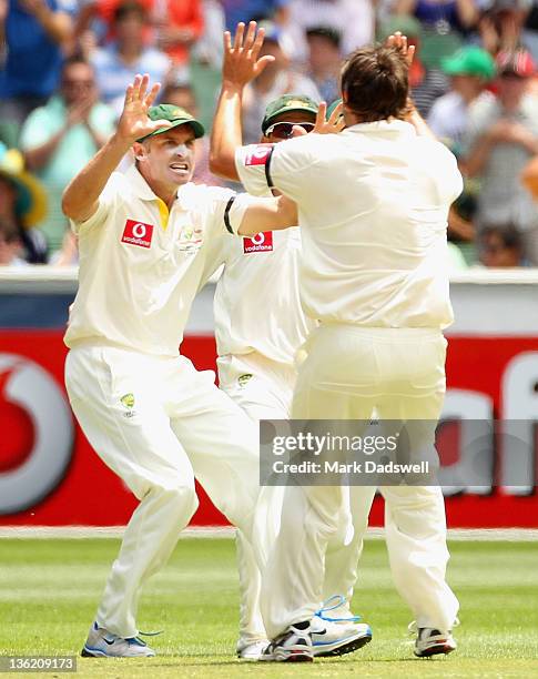 Michael Hussey of Australia celebrates catching Virender Sehwag of India with Ben Hilfenhaus during day four of the First Test match between...