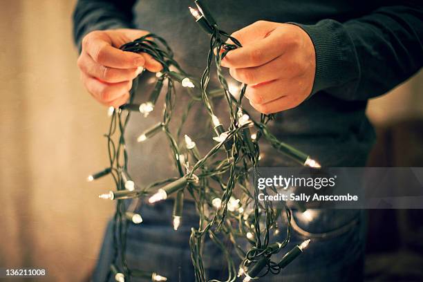 man holding fairy lights. - cadena de luces fotografías e imágenes de stock