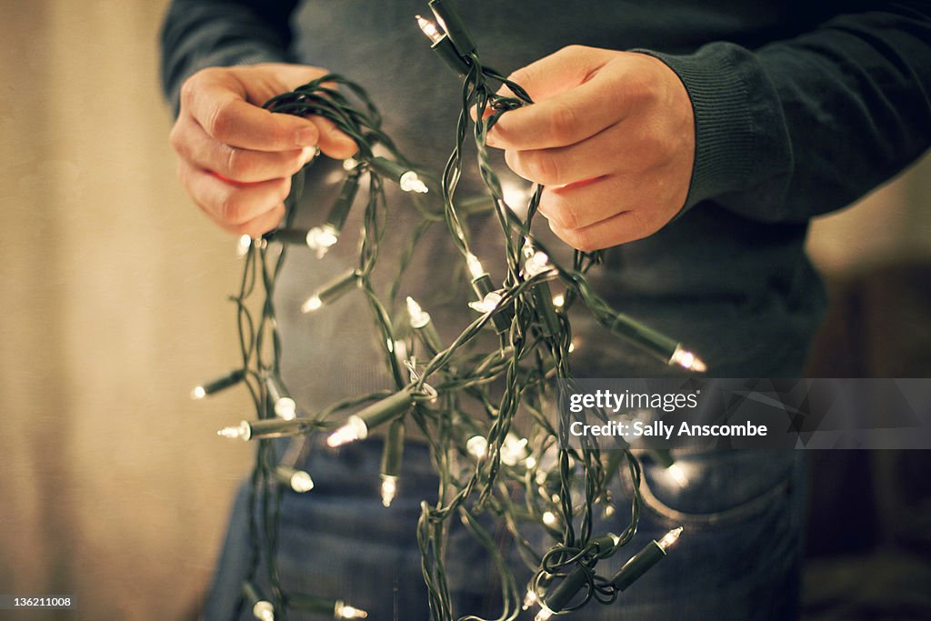 Man holding fairy lights.