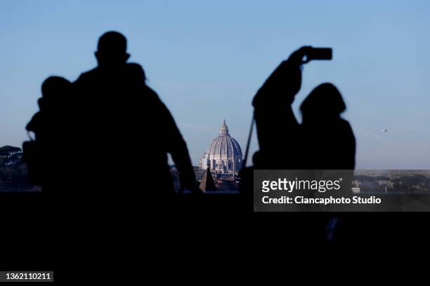 Tourists observe St. Peter's Dome from the "Belvedere Luigi Magni" terrace on December 31, 2021 in Rome, Italy.