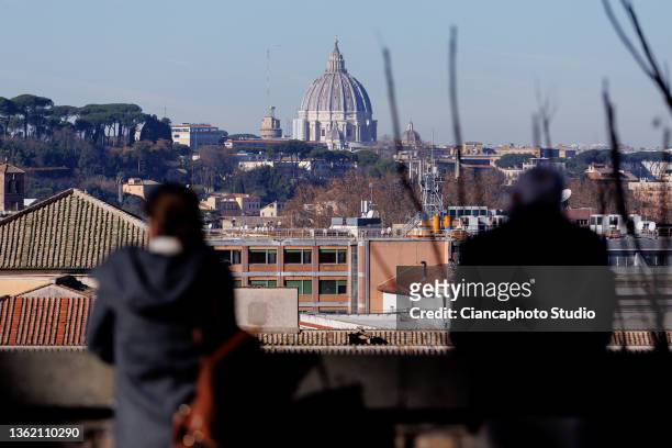 Tourists observe the panorama with the Altare della Patria from the "Belvedere Luigi Magni" terrace near the historic center of Rome on December 31,...