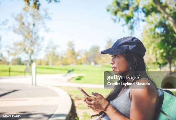 woman at park using cell phone - filipino ethnicity and female not male 個照片及圖片檔