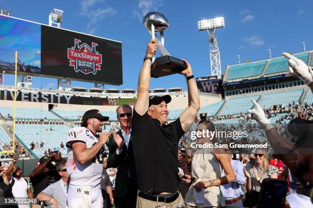 Head coach Dave Clawson of the Wake Forest Demon Deacons holds the trophy following a victory against Rutgers Scarlet Knights 38-10 in the TaxSlayer...