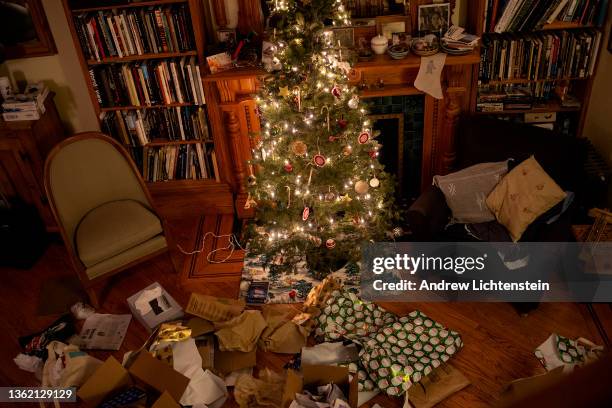 Brooklyn, NEW YORK Discarded wrapping from opened presents surround a Christmas tree on December 25, 2021 in a home in Brooklyn, New York.