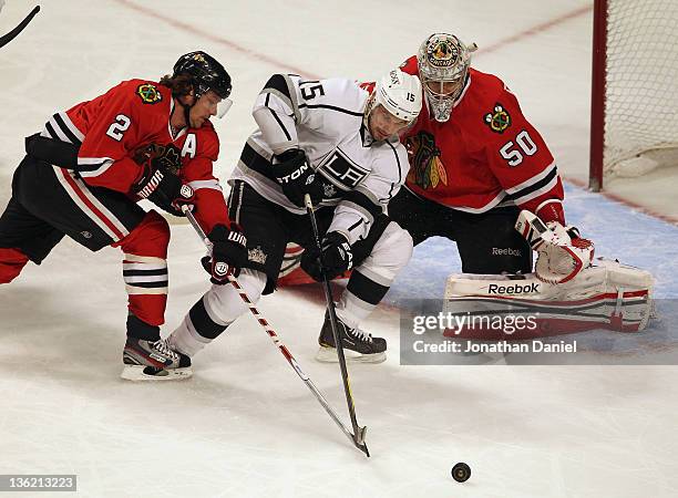 Brad Richardson of the Los Angeles Kings tries to control the puck between Duncan Keith and Corey Crawford of the Chicago Blackhawks at the United...