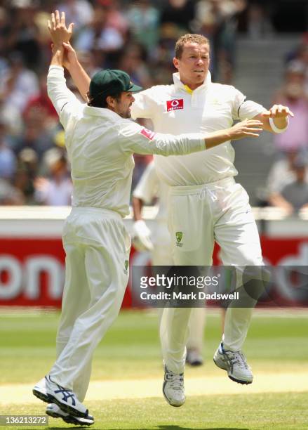 Ed Cowan celebrates with Peter Siddle of Australia after he had Gambhir caught by Ricky Ponting during day four of the First Test match between...