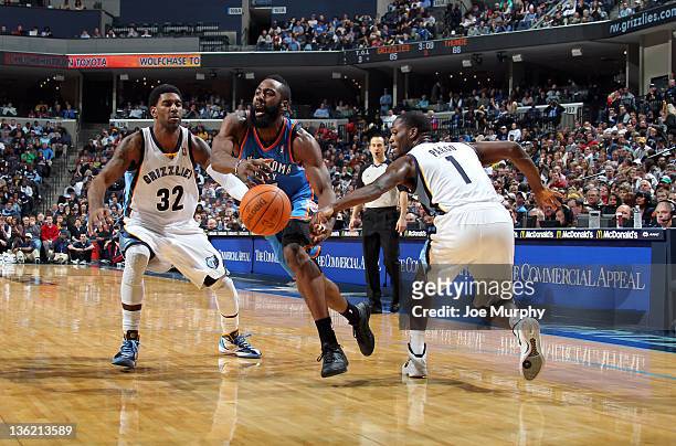 James Harden of the Oklahoma City Thunder drives between O.J. Mayo and Jeremy Pargo of the Memphis Grizzlies on December 28, 2011 at FedExForum in...