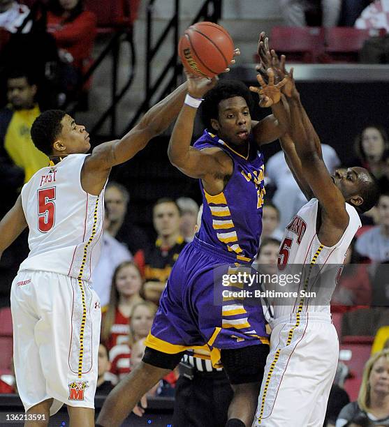 Albany's Gerardo Suero is able to pass the ball despite being defended by Maryland's Nick Faust and James Padgett during 2nd-half action in College...