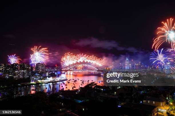 Fireworks light up the sky over the Sydney Harbour Bridge during New Year's Eve celebrations on January 01, 2022 in Sydney, Australia. New Year's Eve...