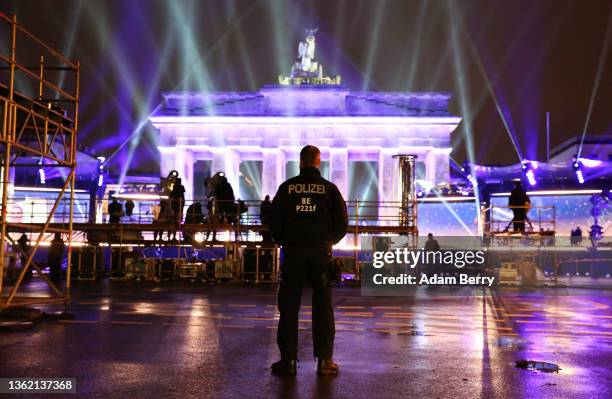 Police officer patrols during televised-only New Year's Eve celebrations held near the Brandenburg Gate on January 01, 2022 in Berlin, Germany. The...