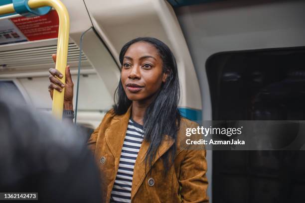 young black woman commuting on london underground - london tube stock pictures, royalty-free photos & images