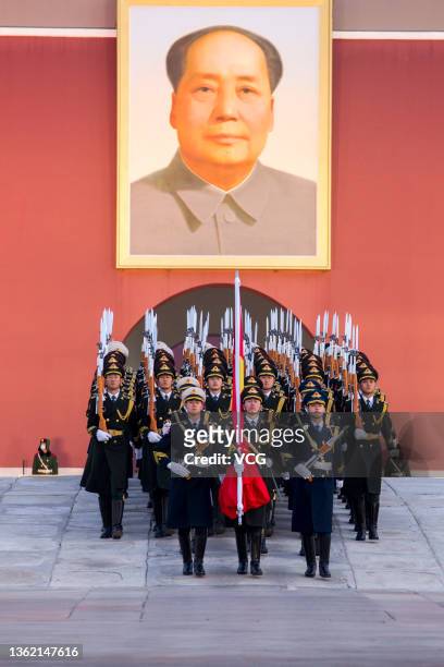 Soldiers of the People's Liberation Army honor guard escort the national flag from the Forbidden City to Tiananmen Square during the flag-raising...