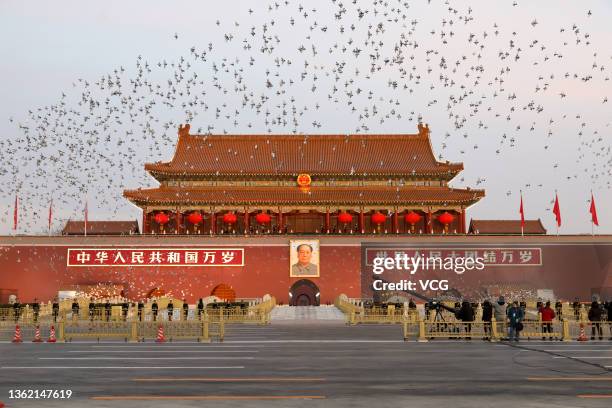 Birds fly over Tiananmen Square during the flag-raising ceremony on New Year's Day on January 1, 2022 in Beijing, China.