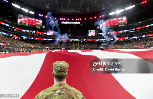 Military person holds an American flag during the pregame ceremonies before the SRS Distribution Las Vegas Bowl between the Arizona State Sun Devils...
