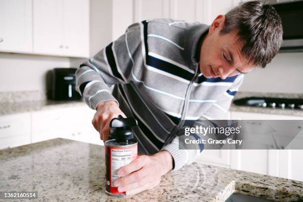 man struggles to open can of food - can opener stock pictures, royalty-free photos & images