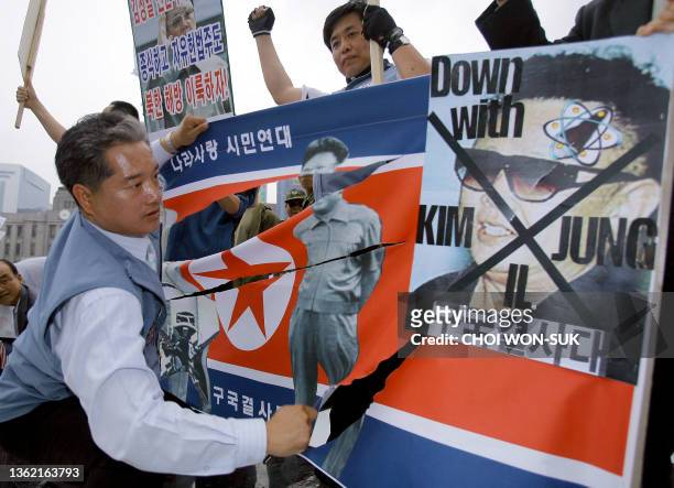South Korean protester cuts off North Korean flag during an anti-North Korea rally in Seoul, 06 June 2007. Tens of thousands of South Korean...