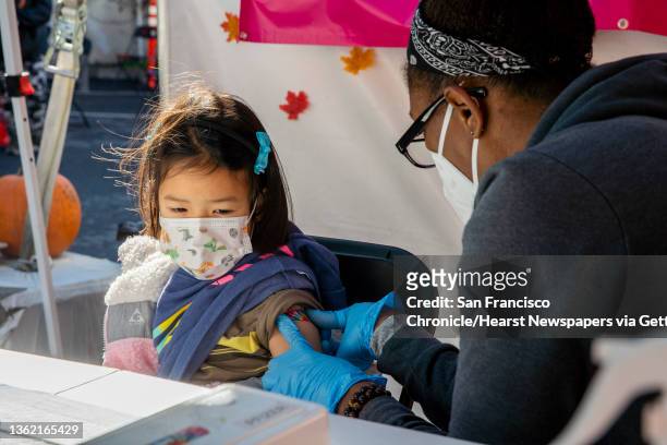 From left: Six-year-old Calista B. At her second appointment for the Pfizer COVID-19 vaccine administered by Alexandria Morrison, Thursday, Dec. 30...
