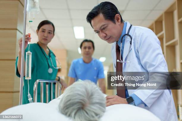 group of medics or doctors carrying unconscious woman patient on hospital gurney to emergency - motion sickness stock pictures, royalty-free photos & images