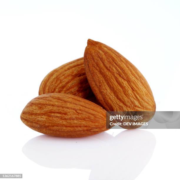 almonds isolated on white - mandeln stock-fotos und bilder