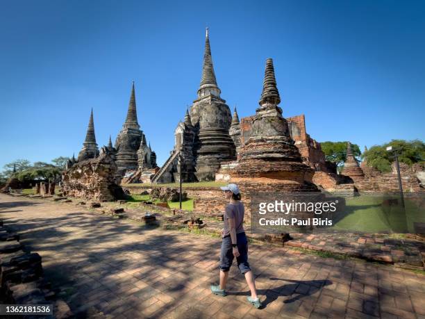 solo tourist, walking through the ancient ruins of wat wat phra si sanphet, of ayutthaya, thailand - ayuthaya imagens e fotografias de stock
