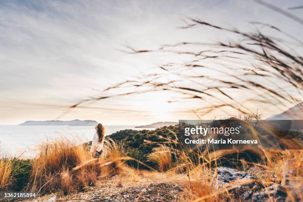 young woman enjoy the sunset on a background of mountains. - grateful stock pictures, royalty-free photos & images