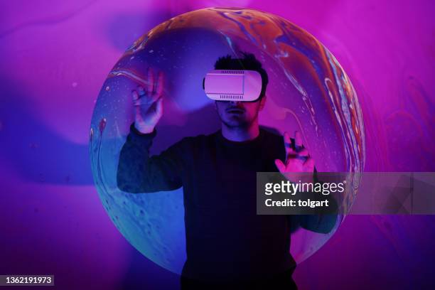 he is discovering metaverse by using vr glasses under neon lights - male abstract stock pictures, royalty-free photos & images
