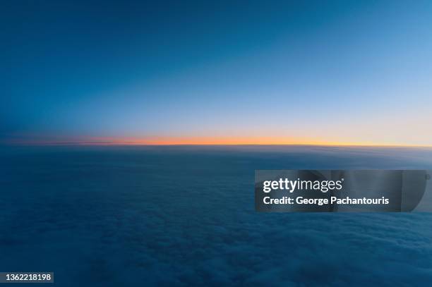 aerial photo of sunrise above the clouds from while in flight - en lo alto posición descriptiva fotografías e imágenes de stock