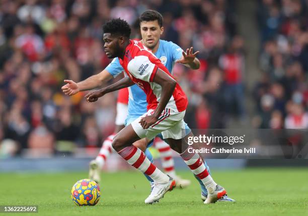 Thomas Partey of Arsenal is challenged by Rodrigo of Manchester City during the Premier League match between Arsenal and Manchester City at Emirates...