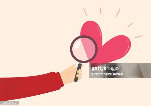 hand holding magnifying glass with heart,love searching - lonely hearts stock illustrations