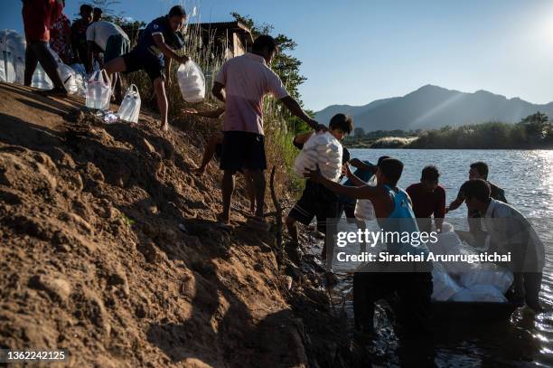 Internally displaced people from Myanmar cross the Moei river to pick up donated food supplies at the river bank as seen from Mae Sot, a district at...