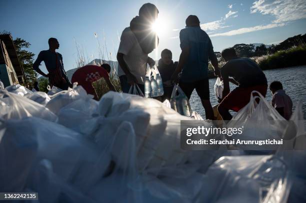 Internally displaced people from Myanmar cross the Moei river to pick up donated food supplies at the river bank as seen from Mae Sot, a district at...