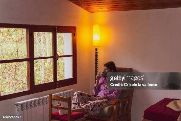 woman in pajamas with her foot bandaged and raised recovering from an injury at home - broken lamp stock pictures, royalty-free photos & images