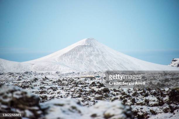 volcanic lava fields covered in snow and snow covered mountain - lava plain stock pictures, royalty-free photos & images