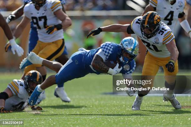 Chris Rodriguez Jr. #24 of the Kentucky Wildcats runs the ball during the first quarter against the Iowa Hawkeyes in the Citrus Bowl at Camping World...