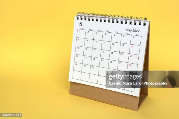 month of may 2022 desk calendar on yellow background - 五月 個照片及圖片檔