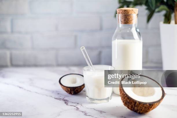 kokosnussgetränk in der flasche auf weißem marmortisch. - kokosnüsse stock-fotos und bilder