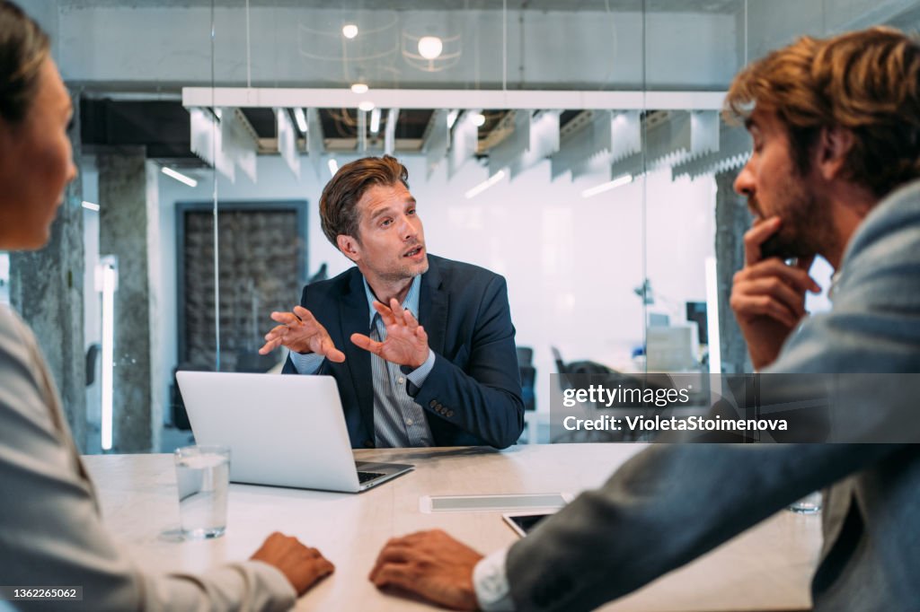 Gruppe von Geschäftsleuten, die im Büro sprechen.
