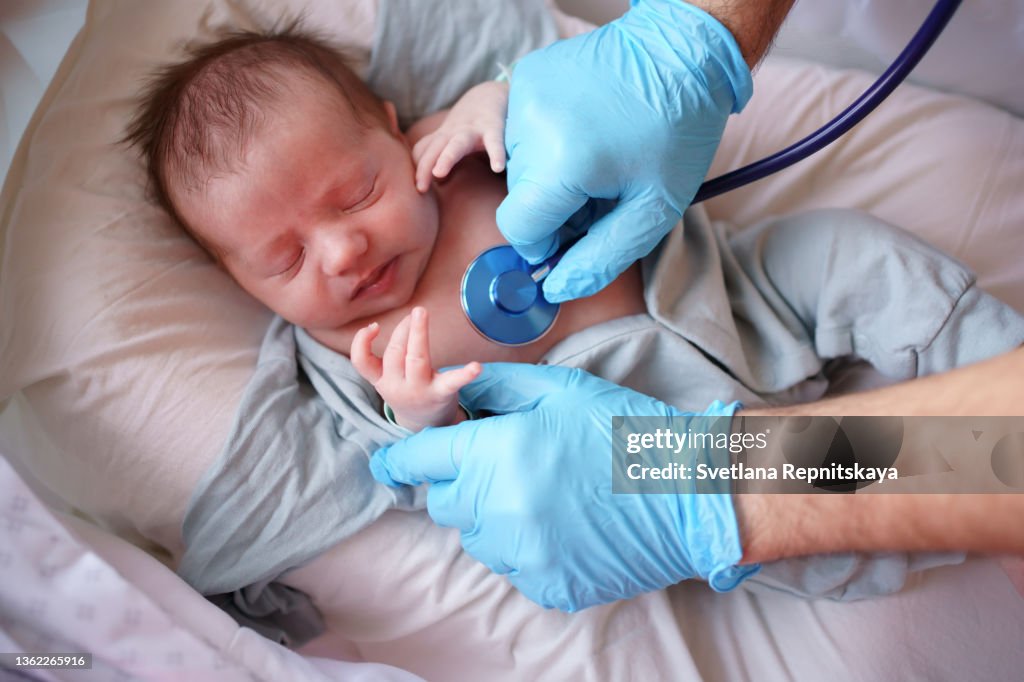 Doctor uses stethoscope to listen to baby