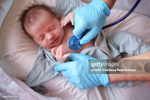 doctor uses stethoscope to listen to baby - illness stockfoto's en -beelden