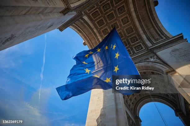 Giant flag of the Euro Union flies at the Arc de Triomphe on the 20th Anniversary of the introduction of the euro on January 01, 2022 in Paris,...